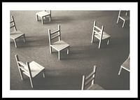 O imagine minimalistă a scaunelor goale împrăștiate pe podea, simbolizând liniștea și spațiul de reflecție-0