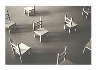 O imagine minimalistă a scaunelor goale împrăștiate pe podea, simbolizând liniștea și spațiul de reflecție-1