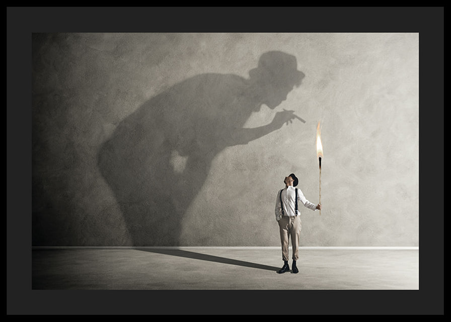 A symbolic image of facing one's inner demons, where a small torch casts a large, confrontational shadow-12