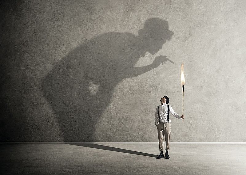 O imagine simbolică a confruntării cu demonii interiori, unde o torță mică aruncă o umbră mare, confruntată-12