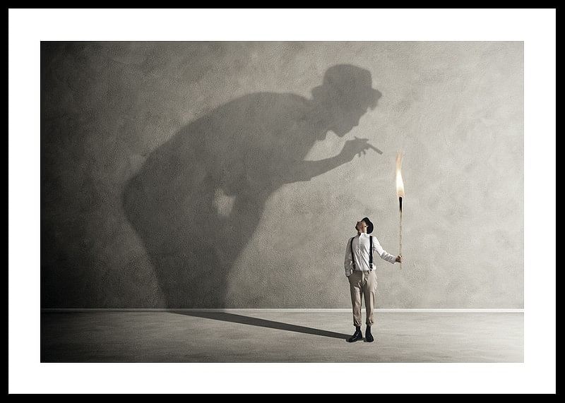 O imagine simbolică a confruntării cu demonii interiori, unde o torță mică aruncă o umbră mare, confruntată-12