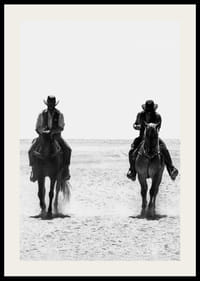 Två cowboys rider sida vid sida genom ett öde landskap, inramade av vilda västerns tidlösa mystik och frihet.-2