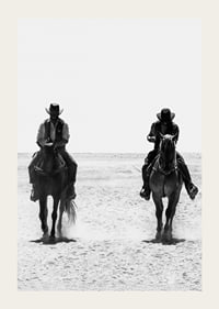 Two cowboys ride side by side through a desolate landscape, framed by the timeless mystery and freedom of the Wild West.-3