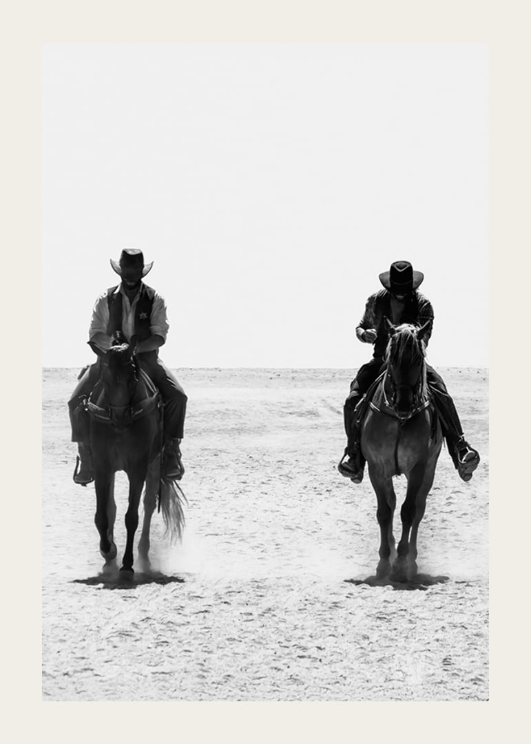 Two cowboys ride side by side through a desolate landscape, framed by the timeless mystery and freedom of the Wild West.-12