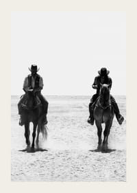 Två cowboys rider sida vid sida genom ett öde landskap, inramade av vilda västerns tidlösa mystik och frihet.-3