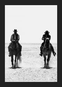 Two cowboys ride side by side through a desolate landscape, framed by the timeless mystery and freedom of the Wild West.-5