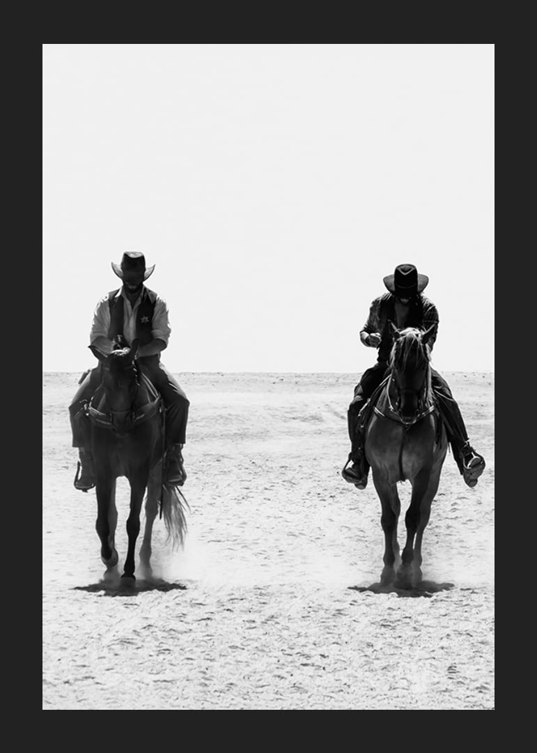 Two cowboys ride side by side through a desolate landscape, framed by the timeless mystery and freedom of the Wild West.-12