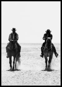 Doi cowboy călătoresc unul lângă altul printr-un peisaj pustiu, încadrat de misterul atemporal și libertatea Vestului Sălbatic.-2
