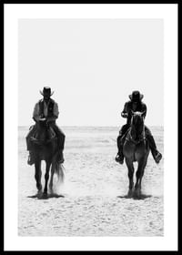 Doi cowboy călătoresc unul lângă altul printr-un peisaj pustiu, încadrat de misterul atemporal și libertatea Vestului Sălbatic.-0
