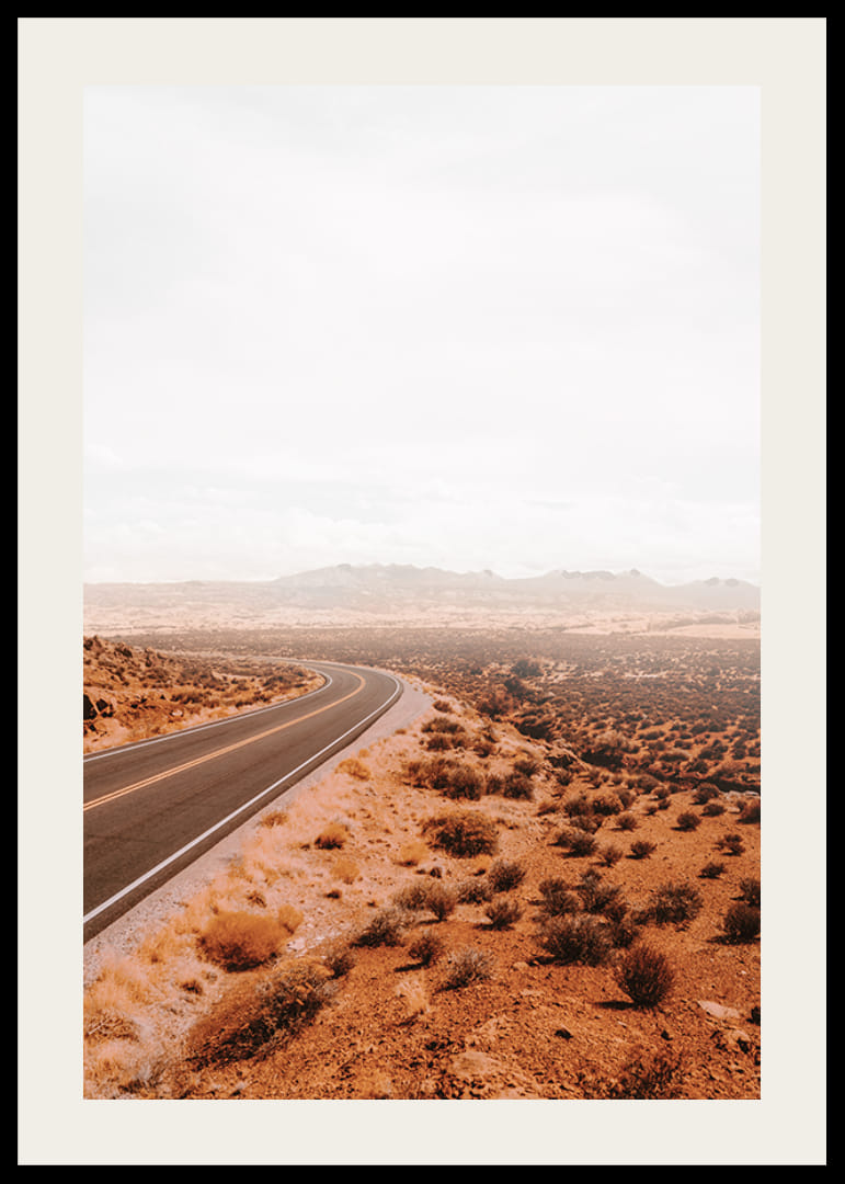 A winding road through the desert landscape that beckons with promises of adventure and freedom on the horizon.-12