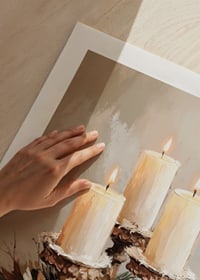 Three lit candles surrounded by evergreen twigs and frosty cones spread a warm and peaceful Christmas atmosphere.-9