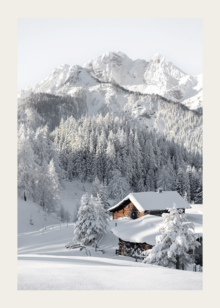 A snow-covered mountain cabin surrounded by frosty trees and majestic mountains that exudes winter idyll and tranquility.-12