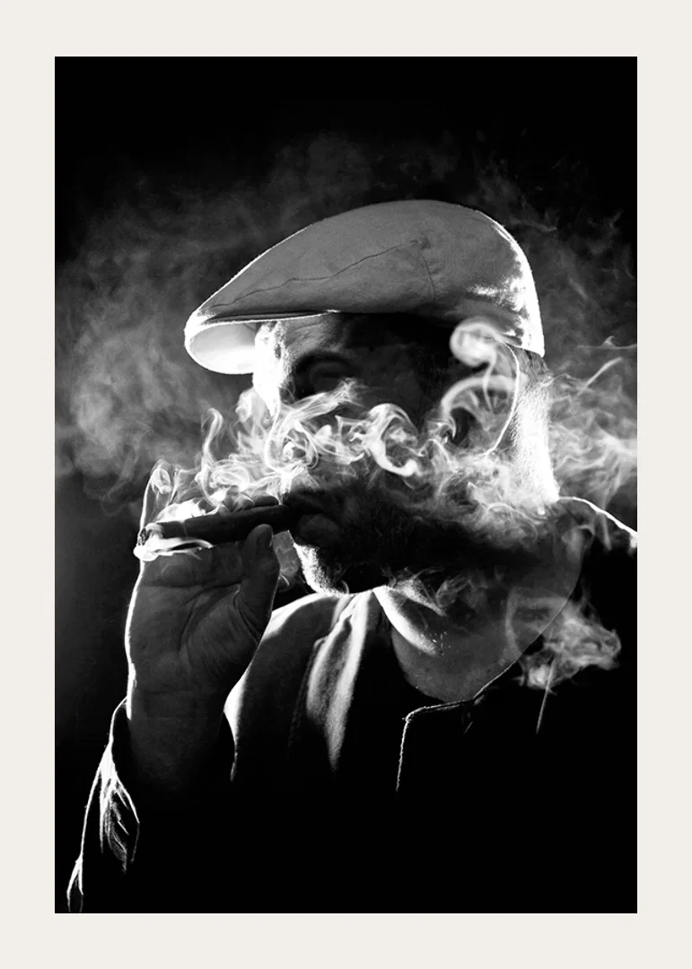 Black and white poster with a photograph of a man in shadows and smoke-12