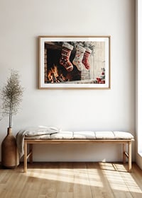 A Christmas poster with decorated Christmas stockings hanging over a cozy crackling fire-8