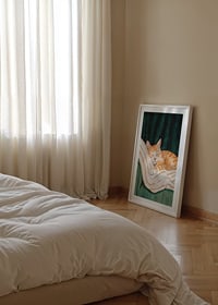 A poster with a sleeping orange cat on a striped blanket in a green armchair-8
