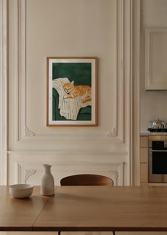 A poster with a sleeping orange cat on a striped blanket in a green armchair-12