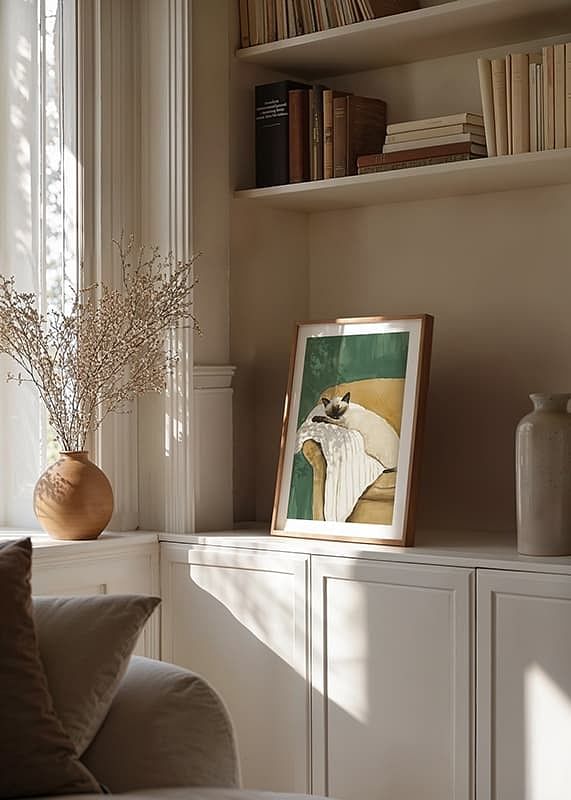 A poster of a sleeping Siamese cat on a striped blanket in a brown armchair-12