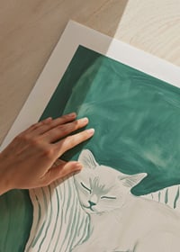 A poster of a sleeping cat on a striped blanket in soft mint green tones-9