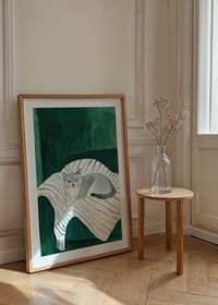 Een poster met een grijze kat die rust op een gestreepte deken in een groene fauteuil-4