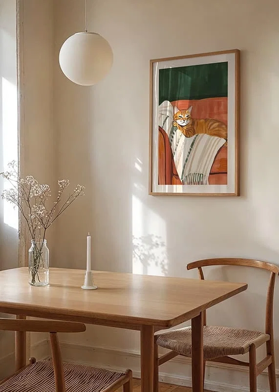 En poster med en orange katt som vilar på en randig filt i en roströd fåtölj-12
