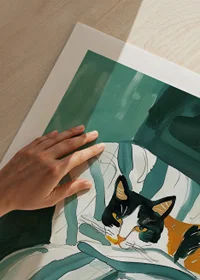 A poster of a tri-colored cat resting on a striped blanket in a green armchair-9