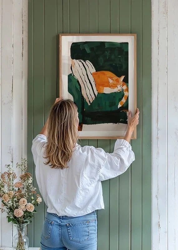En poster med en sovande orange katt på en randig filt i en grön fåtölj-12
