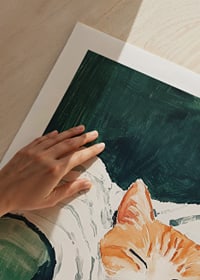 Ein Poster einer schlafenden orangefarbenen Katze auf einer gestreiften Decke-9