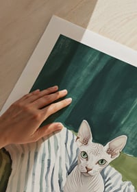 A poster of a sphynx cat on a striped blanket-9
