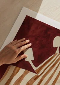 A poster depicting a reading figure in a striped dress against a warm, deep red background-9