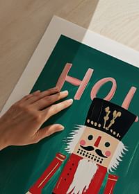 Un afiș cu un spărgător de nuci colorat și textul „Holly Jolly” pe un fundal verde-5