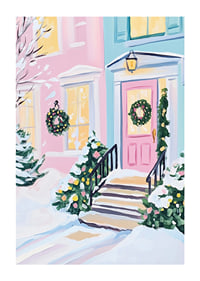 En poster av en pastellfärgad ytterdörr dekorerad med julkransar och snötäckta buskar-1