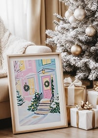 En poster av en pastellfärgad ytterdörr dekorerad med julkransar och snötäckta buskar-8