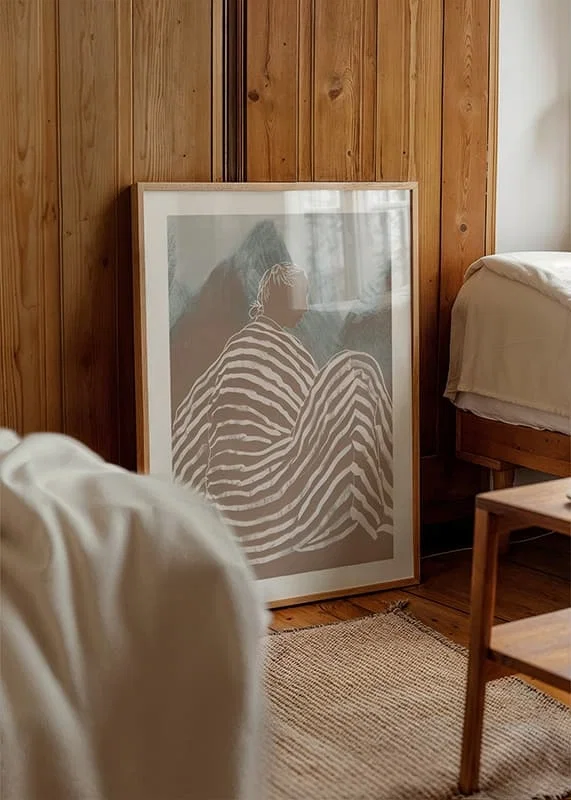 A relaxed figure wrapped in striped fabric against soft mountain tones-12
